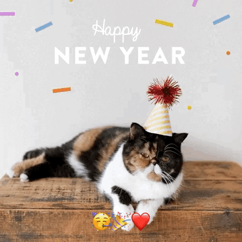 A Calico Cat Wearing A Party Hat Laying On A Wooden Table With The Words Happy New Year Written Above It GIF