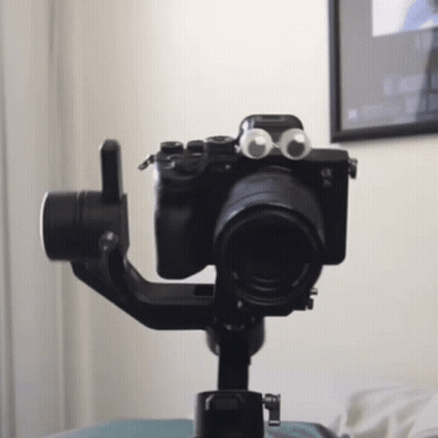 A Camera With Googly Eyes On It Is On A Tripod GIF