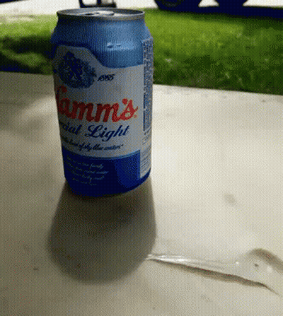 A Can Of Camm 'S Special Light Beer Sits On A Table Outside GIF