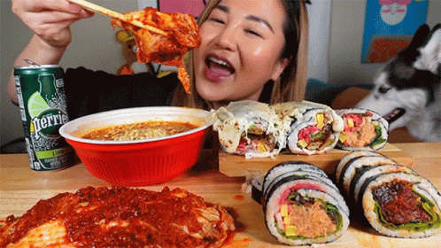 A Can Of Perrier Sits On A Table With A Woman Eating Food GIF