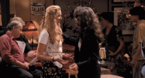A Can Of Salada Coffee Is Hanging On The Wall Behind Two Women GIF