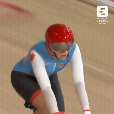 A Canadian Athlete Wearing A Red Helmet And Goggles Is Riding A Bike GIF