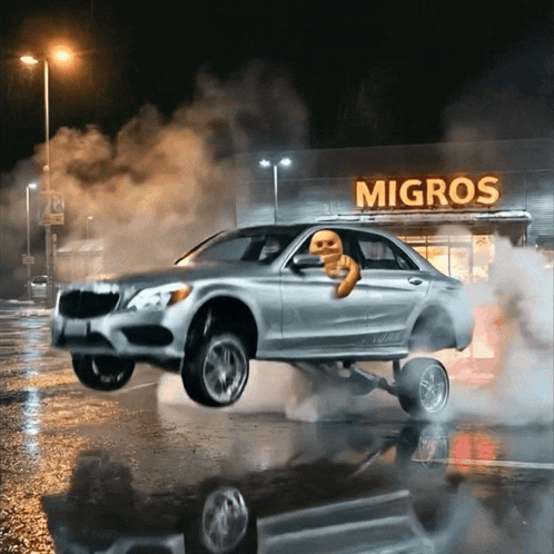 A Car Is Doing A Wheelie In Front Of A Migros GIF