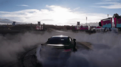 A Car Is Drifting On A Dirt Track With Smoke Coming Out Of It GIF