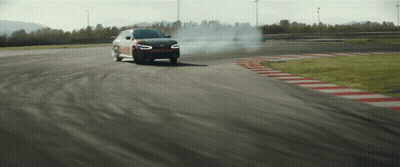 A Car Is Drifting On A Track And Smoke Is Coming Out Of The Tires GIF