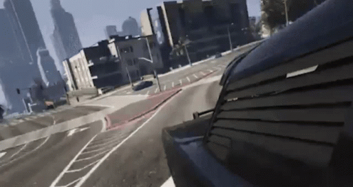 A Car Is Driving Down A City Street With A Few Buildings In The Background GIF