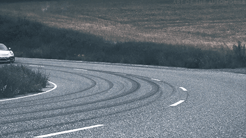 A Car Is Driving Down A Curvy Road With The Words Art Of The Automobile On The Bottom Right GIF