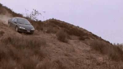 A Car Is Driving Down A Dirt Hill With A License Plate That Says ' Jc ' GIF