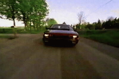 A Car Is Driving Down A Dirt Road In The Countryside GIF