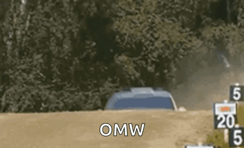 A Car Is Driving Down A Dirt Road With The Words `` Omw '' Written On It . GIF
