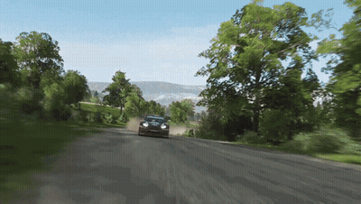 a car is driving down a dirt road with trees on the side