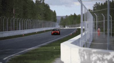 A Car Is Driving Down A Race Track With A Fence Around It GIF