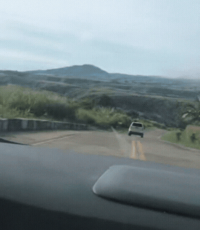 A Car Is Driving Down A Road In The Mountains GIF