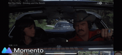 A Car Is Driving Down A Road With A Momento Logo In The Background GIF
