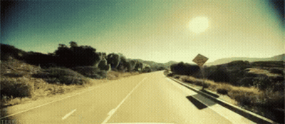 A Car Is Driving Down A Road With A Sign On The Side Of The Road That Says Do Not Enter GIF