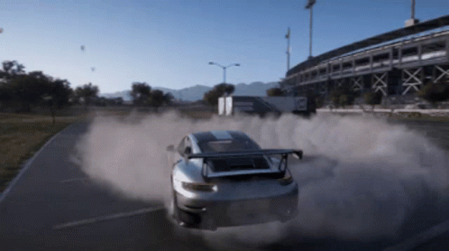 A Car Is Driving Down A Road With Smoke Coming Out Of The Tires GIF