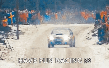 A Car Is Driving Down A Snow Covered Road . GIF
