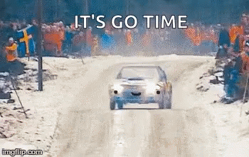 A Car Is Driving Down A Snowy Road With A Crowd Watching . GIF