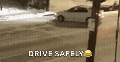 A Car Is Driving Down A Snowy Street With The Words `` Drive Safely '' Written On The Bottom . GIF