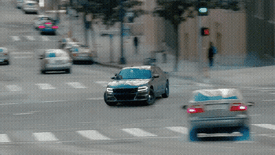 A Car Is Driving Down A Street With A Red Light GIF