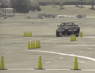 A Car Is Driving Through A Parking Lot With Yellow Cones GIF
