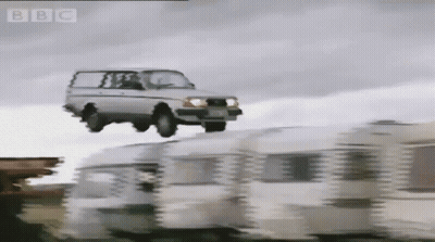 A Car Is Flying Over A Row Of Caravans With The Bbc Logo In The Corner GIF