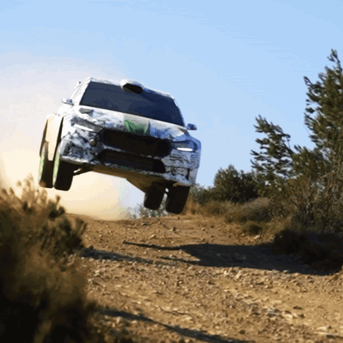 A Car Is Flying Through The Air On A Dirt Track GIF
