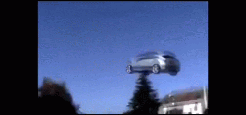 A Car Is Flying Through The Air On A Pole GIF