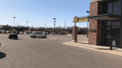 A Car Is Parked In Front Of A Building That Has A Yellow Sign That Says ' Tractor Supply Company ' On It GIF