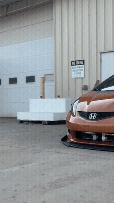 A Car Is Parked In Front Of A Building With A Sign That Says No Parking GIF