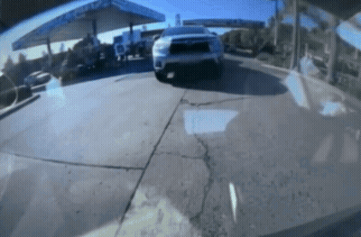 A Car Is Parked In Front Of A Gas Station With A Sign That Says ' Chevron ' On It GIF