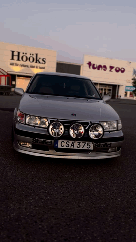 A Car With A License Plate That Says Csa 375 Is Parked In Front Of A Store Called Hooks GIF