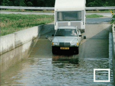 A Car With A License Plate That Says ' Hk-973-Tf ' Is Driving Through A Flooded Road GIF