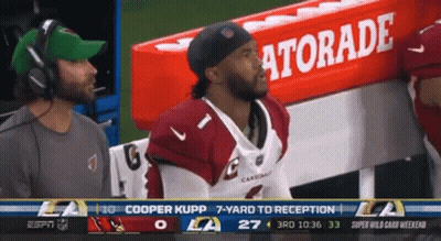 A Cardinals Football Player Sits In The Dugout With A Gatorade Sign In The Background GIF