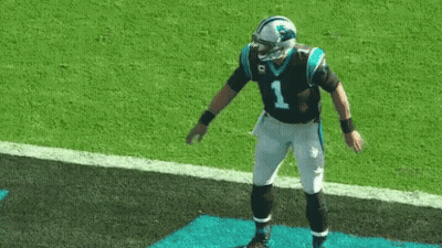 A Carolina Panthers Football Player Is Standing On A Blue Mat On The Field . GIF