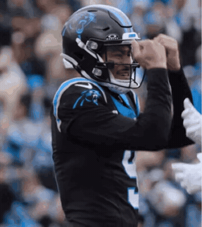 A Carolina Panthers Football Player Wearing A Black Helmet GIF