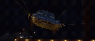 A Cartoon Car Is Flying Through The Air In Front Of A Fire GIF