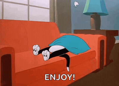 A Cartoon Cat Is Laying On A Red Couch Under A Blue Blanket And Says Enjoy . GIF