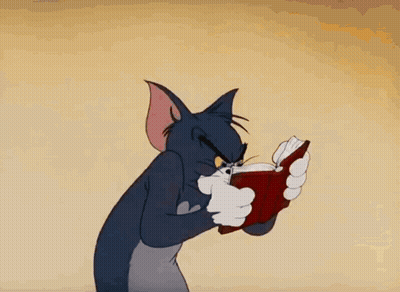 A Cartoon Cat Is Reading A Book With A Very Angry Look On His Face GIF