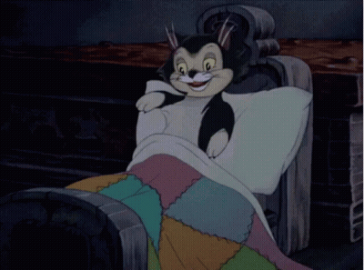 A Cartoon Cat Is Sleeping In A Chair With A Blanket GIF