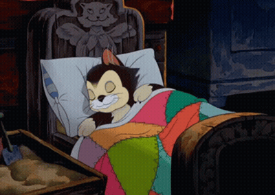 A Cartoon Cat Is Smiling While Sleeping In A Bed GIF