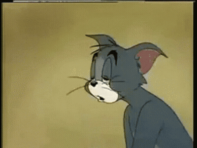 A Cartoon Cat Named Tom Is Sitting Down And Looking At Something GIF