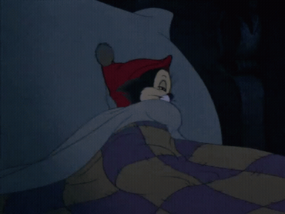 A Cartoon Cat Wearing A Red Hat Is Laying On A Bed GIF