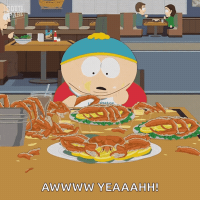A Cartoon Character From South Park Is Sitting At A Table With A Bunch Of Food GIF
