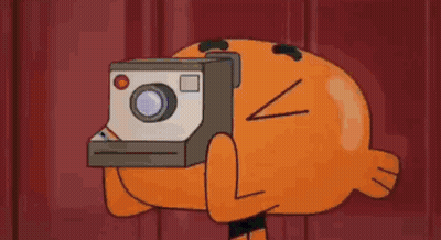 A Cartoon Character From The Amazing World Of Gumball Is Holding A Polaroid Camera . GIF