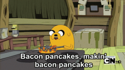 A Cartoon Character Is Cooking Bacon Pancakes On A Stove Top GIF