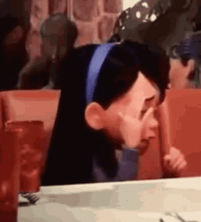 A Cartoon Character Is Crying While Sitting At A Table In A Restaurant . GIF