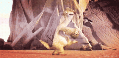 A Cartoon Character Is Holding A Ball In Front Of A Large Rock . GIF