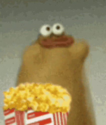 A Cartoon Character Is Holding A Bucket Of Popcorn In Front Of His Mouth . GIF