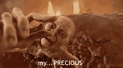A Cartoon Character Is Holding A Ring In His Hand And Says `` My ... Precious '' . GIF